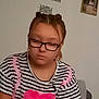 casual, child, earphones, expressionless, face, furniture, girl, glasses, hair_buns, head, home, indoor, person, picture_frames, pink_heart, portrait, seated, striped_shirt, wall, young