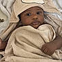 baby, towel, hooded_towel, bear_design, infant, blanket, soft_texture, cute, child, wrapped, sleepwear, indoor, portrait, skin, hand, face, eyes, lying_down, comfort, warm