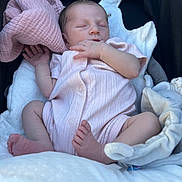 Léna participe au concours pour gagner de l'argent avec cette photo : baby, newborn, sleeping, onesie, pink_clothing, blanket, stroller, plush_toy, infant, cute, peaceful, soft_texture, hand, foot, face, resting, child, cozy, comfort, indoor