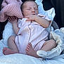 baby, newborn, sleeping, onesie, pink_clothing, blanket, stroller, plush_toy, infant, cute, peaceful, soft_texture, hand, foot, face, resting, child, cozy, comfort, indoor