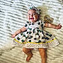 baby, blanket, butterfly_pattern, child, colorful, cute, dress, fabric, feet, hands, happy, headband, indoor, infant, lying_down, portrait, seven_months, smiling, soft_texture, wooden_sign
