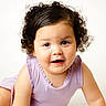 toddler, child, curly_hair, portrait, smiling, face, person, baby, cute, indoors, clothing, purple_outfit, expression, skin, hair, young_child, studio, head_and_shoulders, looking_at_camera, happy