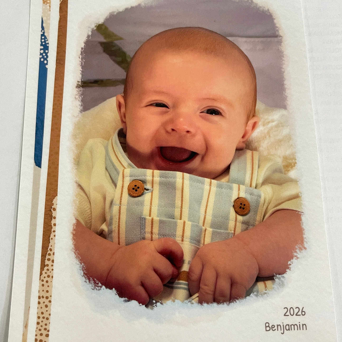 Benjamin is registered to the contest to win money with this photo: baby, smiling, laughing, infant, overalls, striped_clothing, wooden_buttons, portrait, baby_photo, card, printed_photo, decorative_border, white_vignette, happy, cute, child, hands, face, head, indoor