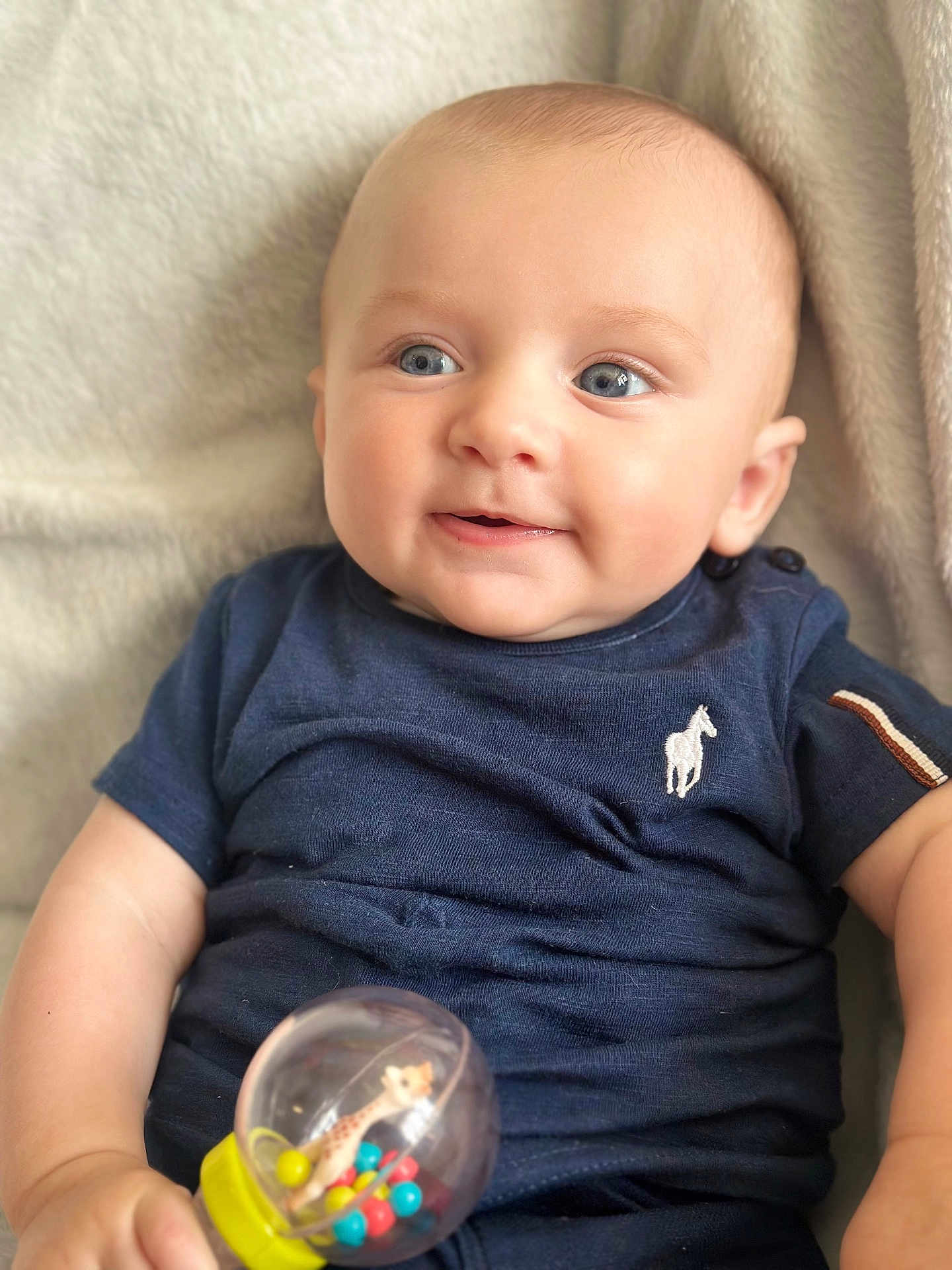 Adam a rejoint le concours — aidez-le/la à gagner de superbes lots ! baby, infant, blue_eyes, smile, rattle, toy, giraffe, clothing, short_sleeve, blanket, cute, child, person, skin, face, hand, indoor, soft, happy, portrait