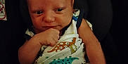 Kash is registered to the contest to win money with this photo: baby, infant, blanket, dinosaur_print, clothing, face, hand, arm, car_seat, seat, person, child, cute, expression, indoors, portrait, newborn, resting, infant_clothing, baby_garment