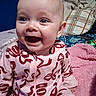 Piper joined the competition — help win amazing prizes! baby, infant, child, smiling, laughing, portrait, close_up, face, eyes, mouth, pink, onesie, bow_pattern, sitting, blanket, pillow, bed, indoor, happy, cozy