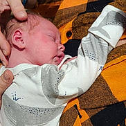 Varek joined the competition — help win amazing prizes! baby, newborn, sleeping, infant, onesie, whale_pattern, hand, orange_shirt, checkered_shirt, person, closeup, indoor, caring, gentle, rest, peaceful, skin, face, cozy, love