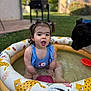 Zoé a rejoint le concours — aidez-le/la à gagner de superbes lots ! animal, backyard, black_dog, blue_swimsuit, child, daylight, dog, grass, happy, inflatable_pool, outdoor, pet, pigtails, playful, pool, sitting, summer, toddler, toy, water