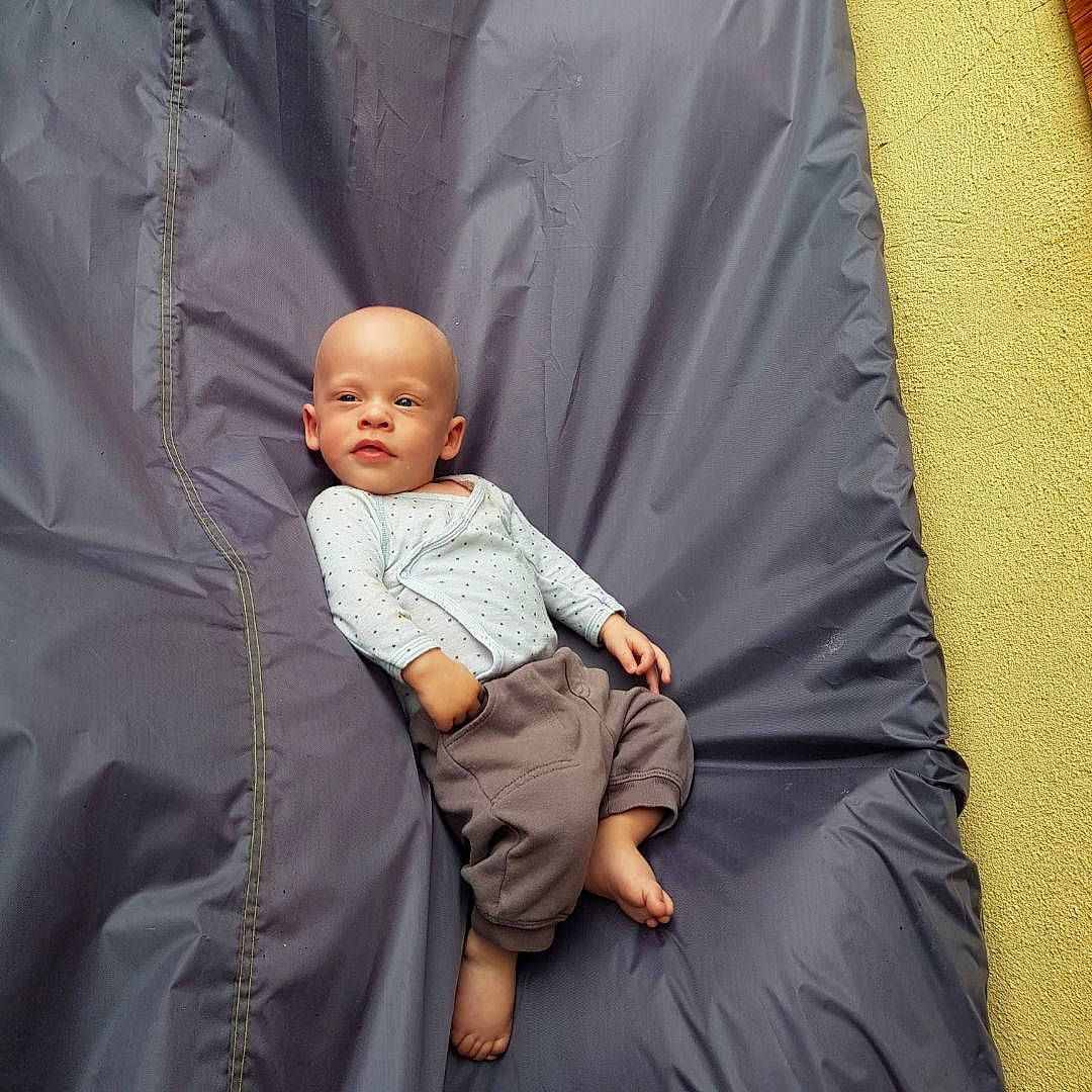 François participe au concours pour gagner de l'argent avec cette photo : baby, baby_products, baby_toddler_clothing, child, comfort, event, grey, lap, linens, person, product, room, sitting, sleeve, t_shirt, toddler