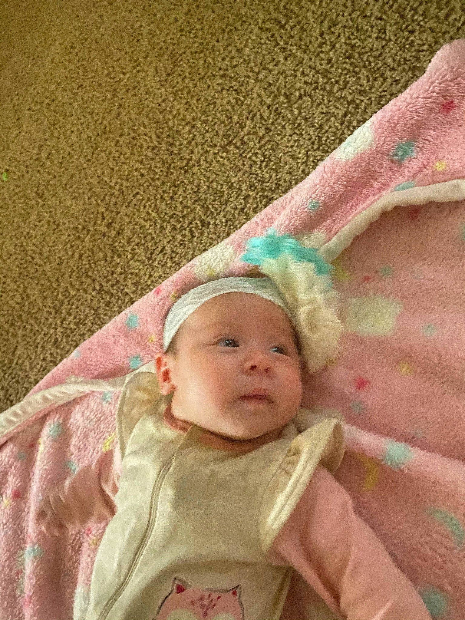 Rebekah is registered to the contest to win money with this photo: baby, baby_products, baby_toddler_clothing, cheek, chin, comfort, eye, eyebrow, fashion_accessory, grass, headwear, human_body, iris, linens, nose, person, pink, sitting, skin, sleeve