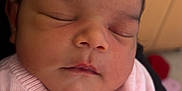 Mila Abbott is registered to the contest to win money with this photo: baby, sleeping, infant, pink_sweater, closeup, face, child, soft_lighting, indoors, cute, peaceful, newborn, portrait, young_child, skin, hair, buttoned_sweater, resting, calm, toddler