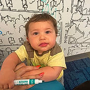 Amir joined the competition — help win amazing prizes! toddler, child, face, marker, hand, yellow_shirt, curly_hair, wall_art, blue_carpet, nails, orange_nail_polish, indoor, cute, expression, person, drawing, playful, young_child, marker_pen, holding