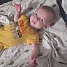 Bruce joined the competition — help win amazing prizes! baby, infant, crib, blanket, bee_pattern, yellow_shirt, smile, hand, lying_down, face, child, indoor, cute, apparel, text_on_clothing, bedroom, soft_lighting, young_child, person, expression