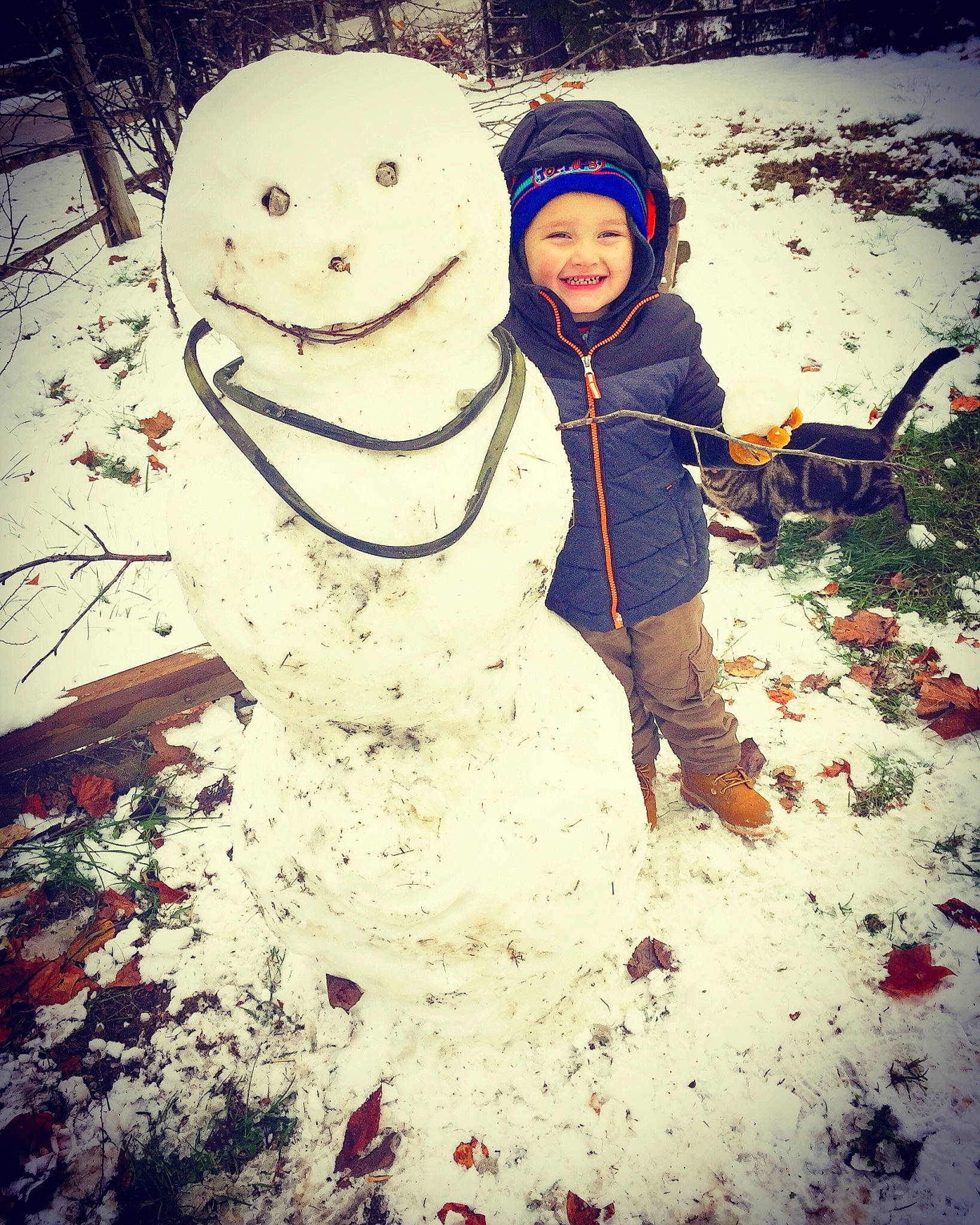Dayton is registered to the contest to win money with this photo: child, cloud, cool, freezing, fun, happy, headwear, joy, mountain, person, play, playing_in_the_snow, sky, smile, snow, snowman, winter
