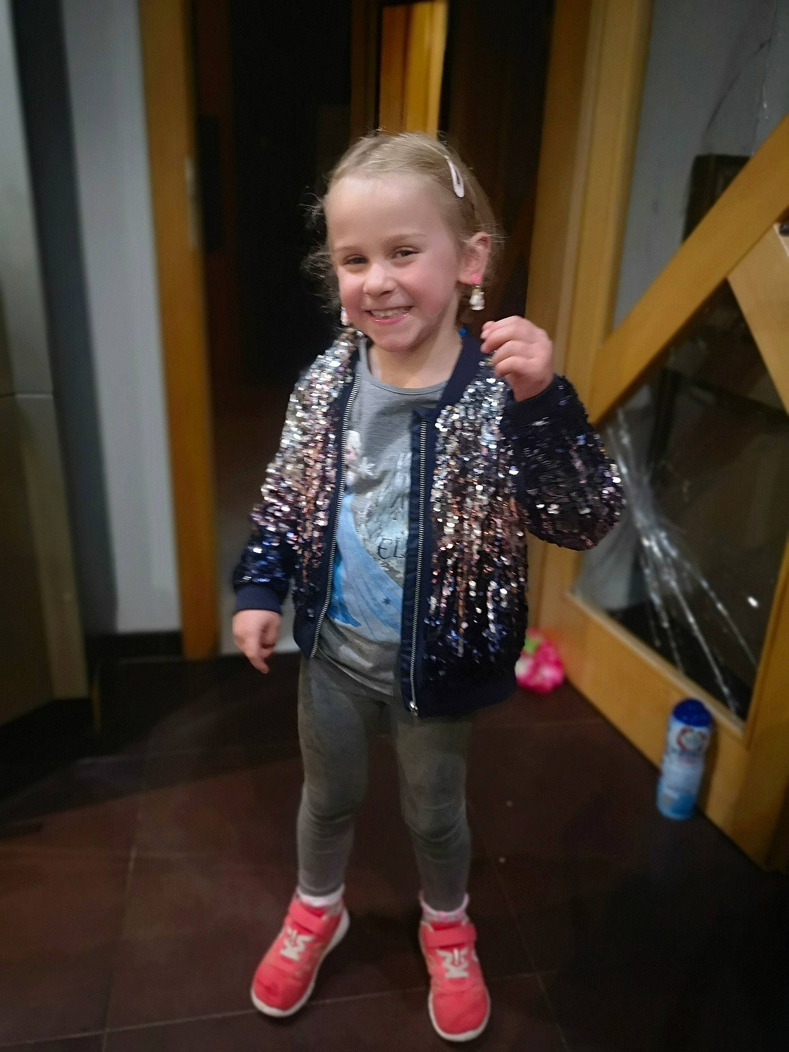 Carla participe au concours pour gagner de l'argent avec cette photo : baby_toddler_clothing, cheek, child, door, event, flooring, fun, happy, head, joy, leisure, pattern, person, sitting, sleeve, smile, standing, t_shirt, toddler, wood