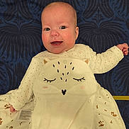 Louna participe au concours pour gagner de l'argent avec cette photo : animal_design, baby, blanket, blue_background, child, clothing, cute, face, happy, indoor, infant, lying_down, newborn, onesie, pattern, person, portrait, smiling, soft_fabric, warm