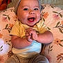 Oaklynn is registered to the contest to win money with this photo: baby, smiling, happy, headband, clothing, hands, face, infant, cushion, floral_pattern, sitting, indoors, cute, child, portrait, cheerful, skin, person, head, eyes