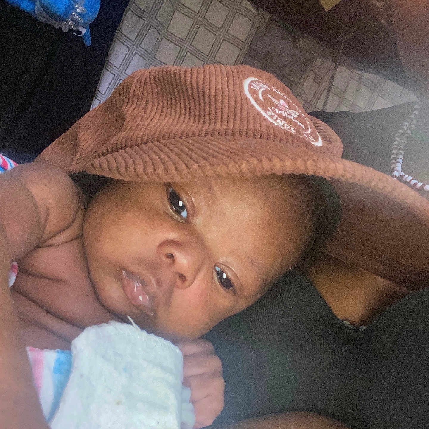 Antonio Jr is registered to the contest to win money with this photo: baby, infant, hat, blanket, closeup, face, skin, child, sleepy, resting, corduroy, soft_toy, indoor, person, newborn, portrait, hand, cute, relaxing, comfort