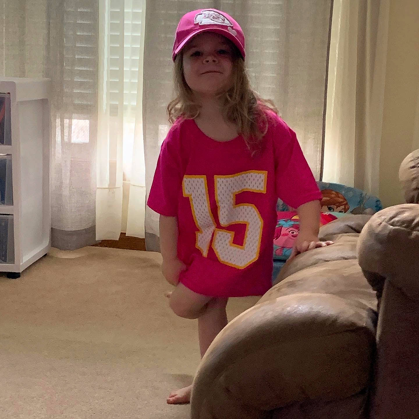 Kensley joined the competition — help win amazing prizes! cap, fun, headgear, headwear, leg, magenta, outerwear, person, pink, sitting, t_shirt