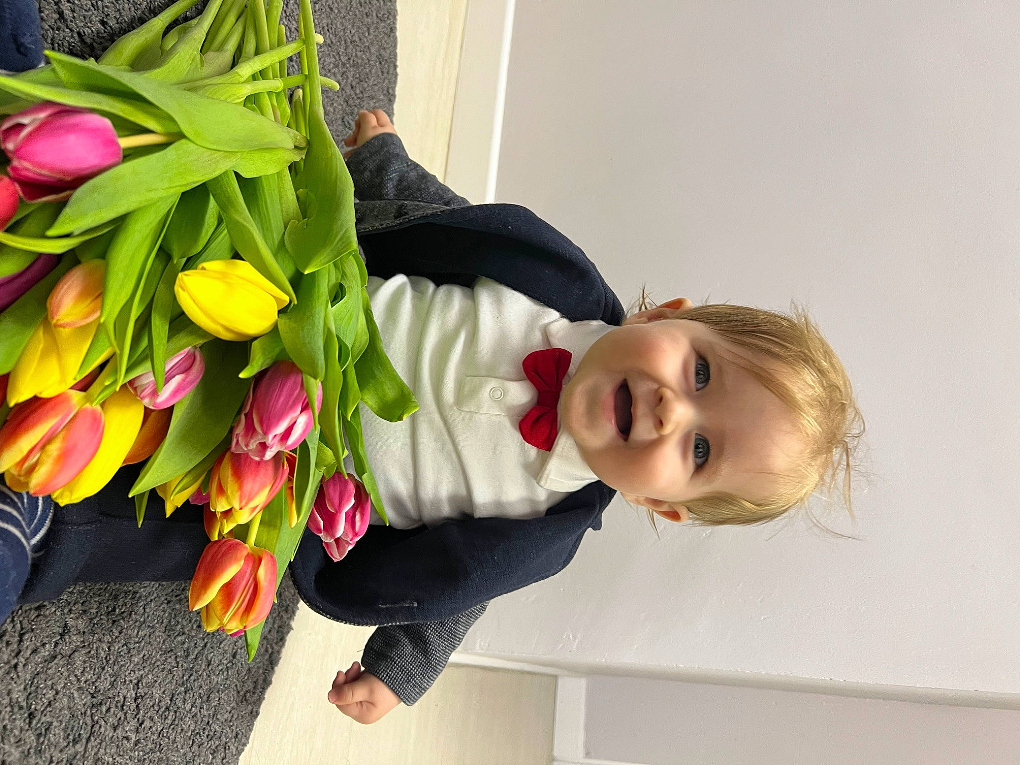 Timotei a rejoint le concours — aidez-le/la à gagner de superbes lots ! artificial_flower, baby, bouquet, child, cut_flowers, dress, floral_design, floristry, flower, flower_arranging, flowering_plant, happy, iris, jeans, magenta, person, petal, plant, skin, smile