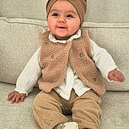 Giulia participe au concours pour gagner de l'argent avec cette photo : baby, child, infant, smiling, sitting, headwrap, bow, vest, corduroy_pants, white_shoes, couch, textured_fabric, cozy, indoors, cute, happy, portrait, young_child, fashion, comfortable