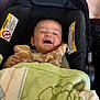 baby, car_seat, child, smiling, plush_toy, giraffe, blanket, happy, infant, cute, face, clothing, comfort, indoor, seat, young_child, portrait, person, cozy, resting