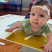 Tyler joined the competition — help win amazing prizes! baby, child, headband, blue_eyes, green_shirt, daisy_pattern, carpet, alphabet_rug, hand, floor, indoor, furniture, pink_chair, playroom, curious, portrait, tummy_time, infant, cute, home