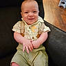 Nathan joined the competition — help win amazing prizes! baby, child, smiling, indoor, plaid_shirt, green_shorts, suspenders, chair, wooden_floor, person, cute, happy, infant, sitting, portrait, clothing, baby_clothes, face, human, young_child