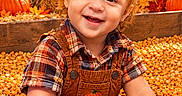 Nathan is registered to the contest to win money with this photo: autumn, child, corn, corn_pit, fall, farm, harvest, orange, outdoor, overalls, plaid_shirt, portrait, pumpkin, pumpkin_patch, rustic, scarecrow, smiling, sunflower, toddler, wooden_sign