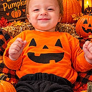 Nathan joined the competition — help win amazing prizes! autumn, autumn_leaves, black_pants, child, close_up, fall, festive, halloween, happy, hay, indoor, jack_o_lantern, lantern, orange_shirt, portrait, pumpkin, seasonal_decor, sitting, smiling, toddler