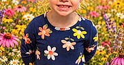 Paisley is registered to the contest to win money with this photo: child, girl, portrait, smiling, sunset, flower_field, wildflowers, garden, outdoor, nature, dress, floral_pattern, blonde_hair, ponytail, happy, standing, sunlight, colorful, summer, daisy