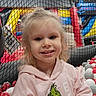 ball_pit, blonde_hair, casual_clothing, child, colorful, cute, fun, gray_balls, grinch, happy, hoodie, indoor, indoor_play_area, net, playground, portrait, red_balls, smiling, white_balls, young_child