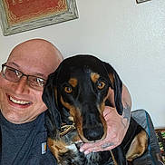 Bennie Lee joined the competition — help win amazing prizes! black_and_tan_dog, brown_eyes, close_up, collar, couch, dog, framed_art, friendship, glasses, hand, happy, home_decor, indoor, person, pet, portrait, selfie, smile, tattoo, wall