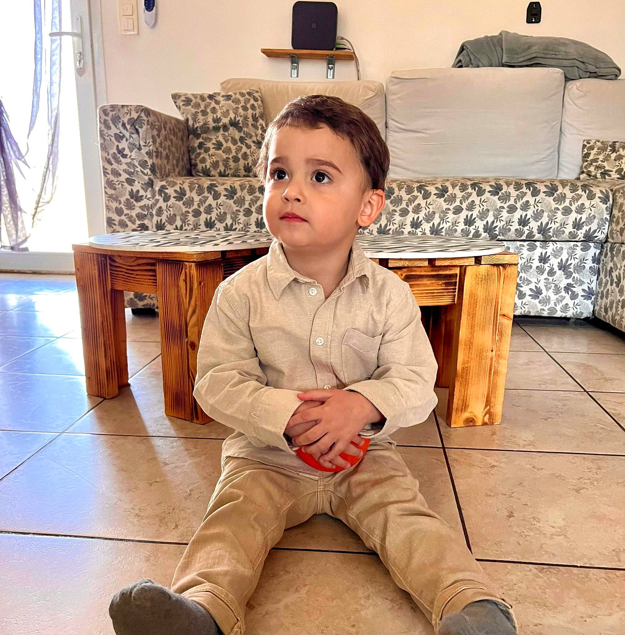 Santu a rejoint le concours — aidez-le/la à gagner de superbes lots ! baby_toddler_clothing, comfort, curtain, eye, floor, flooring, happy, hardwood, head, human_body, knee, laminate_flooring, lamp, living_room, person, sitting, sleeve, thigh, toddler, wood