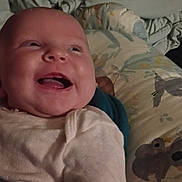 Annabelle is registered to the contest to win money with this photo: baby, infant, child, smiling, laughing, face, portrait, bed, bedding, blanket, pillow, bedroom, indoors, clothing, pink_outfit, happy, joyful, sitting, close_up, animal_pattern
