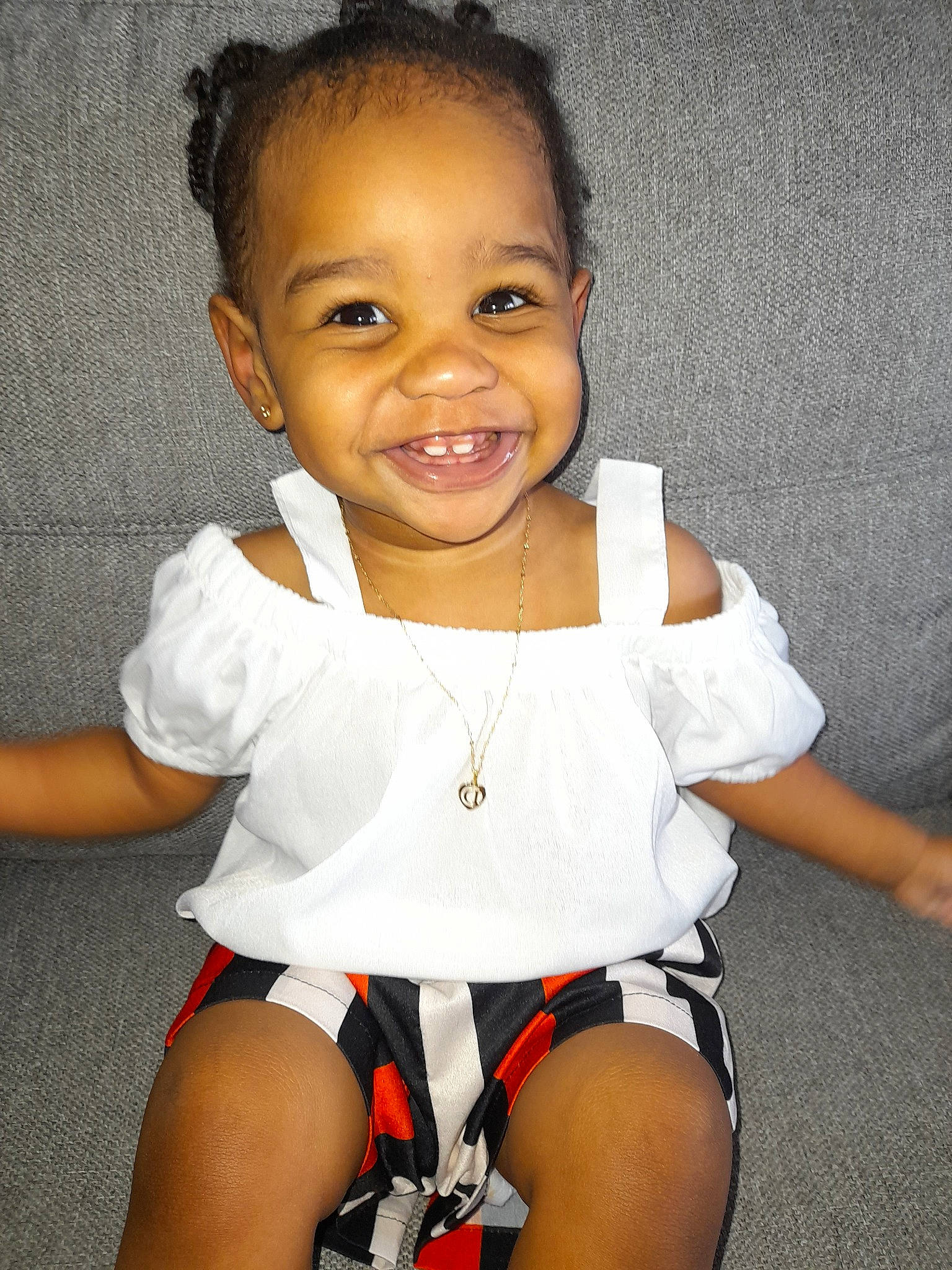 Daïna participe au concours pour gagner de l'argent avec cette photo : abdomen, baby_toddler_clothing, black_hair, cheek, chest, dress, facial_expression, flash_photography, hair, happy, joy, leg, neck, person, skin, sleeve, smile, t_shirt, thigh, toddler