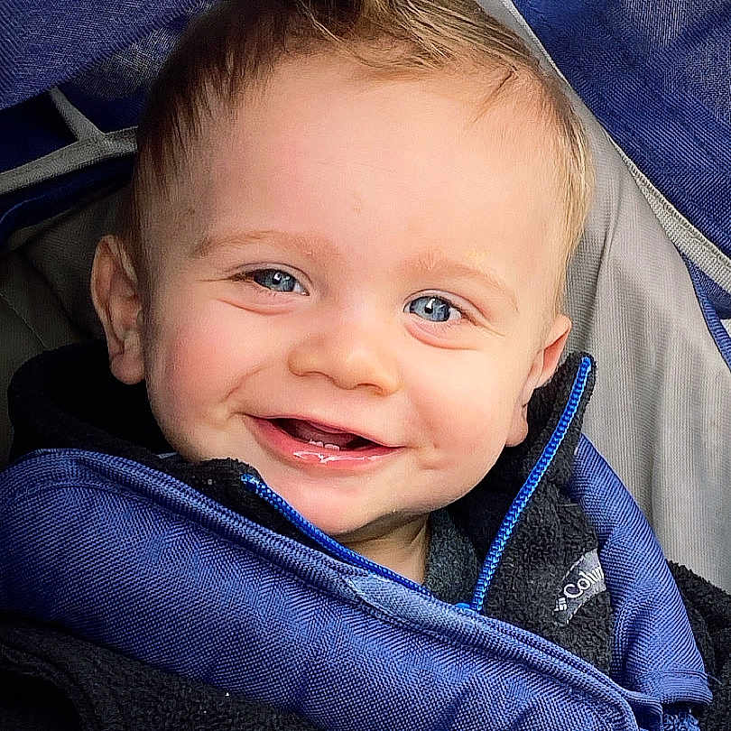 Wesley is registered to the contest to win money with this photo: accessories, baby, babylaughing, clothing, coat, face, happy, head, jacket, knitwear, laughing, pants, person, photography, portrait, smile, strap, stroller, sweater, sweatshirt