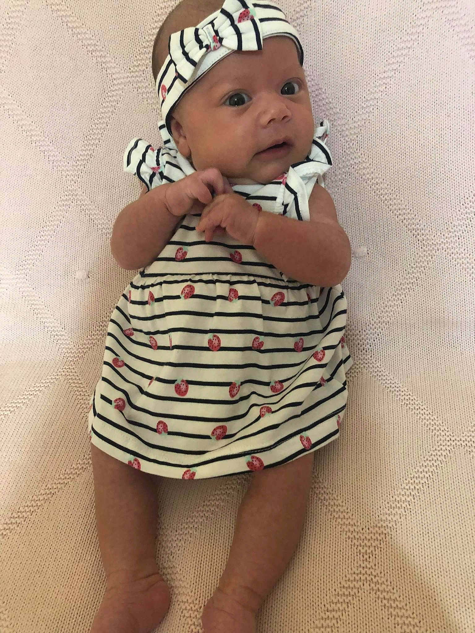 Celine joined the competition — help win amazing prizes! arm, baby, baby_toddler_clothing, cap, elbow, face, finger, gesture, hand, happy, headwear, human_leg, iris, lip, one_piece_garment, pattern, person, skin, sleeve, thigh