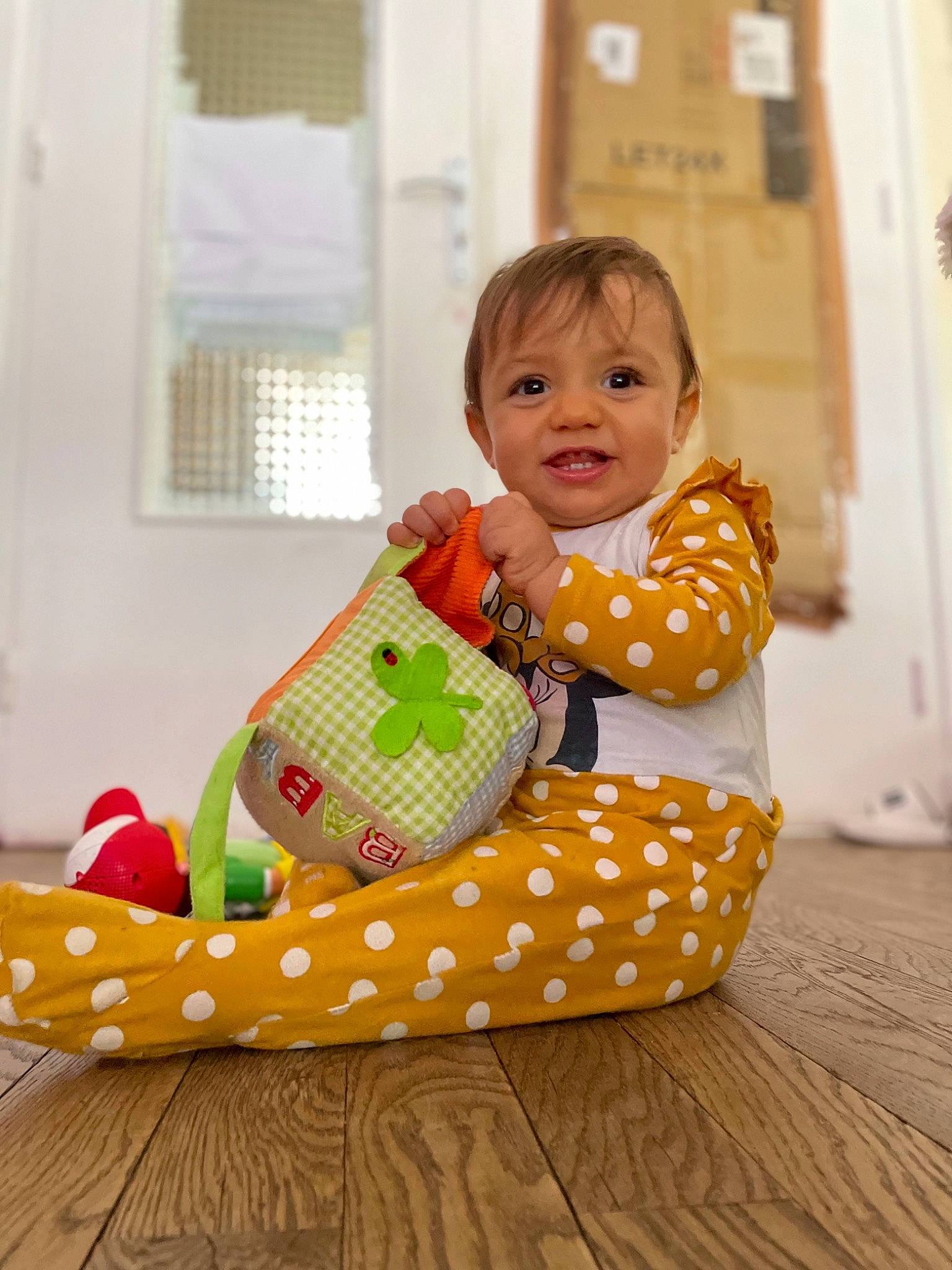 Mya a rejoint le concours — aidez-le/la à gagner de superbes lots ! baby, baby_products, baby_toddler_clothing, bag, child, comfort, event, floor, flooring, fun, happy, pattern, person, play, room, sitting, smile, toddler, window, window_blind