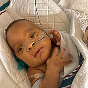 Kaison is registered to the contest to win money with this photo: baby, bed, blanket, child, cute, face, feeding_tube, hand, healthcare, hospital, hospital_bed, infant, lying_down, medical, newborn, patient, person, skin, swaddled, wrapped