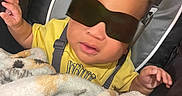 Kaison is registered to the contest to win money with this photo: baby, baby_seat, blanket, casual, child, comfort, cozy, curly_hair, cute, expression, face, fashion, hand, indoor, infant, portrait, relaxing, sunglasses, yellow_shirt, young