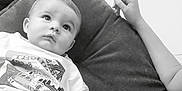 Gino a rejoint le concours — aidez-le/la à gagner de superbes lots ! baby, child, couch, pillow, toddler, shirt, shorts, arm, hand, face, person, indoor, black_and_white, seated, relaxed, curious, clothing, furniture, portrait, casual