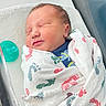 newborn, baby, infant, sleeping, peaceful, face, portrait, blanket, swaddled, pacifier, hospital, bassinet, indoor, cozy, head, closed_eyes, patterned_fabric, nursery, resting, photography