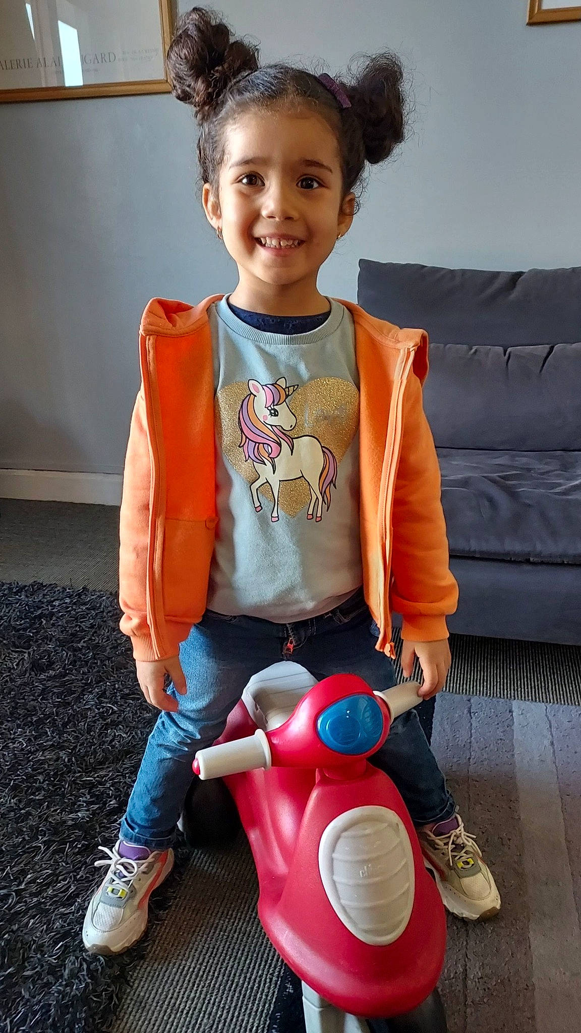 Fleur participe au concours pour gagner de l'argent avec cette photo : baby_toddler_clothing, boot, carmine, child, electric_blue, face, happy, jeans, joy, people, person, personal_protective_equipment, recreation, riding_toy, shoe, sitting, sleeve, smile, snapshot, sneakers