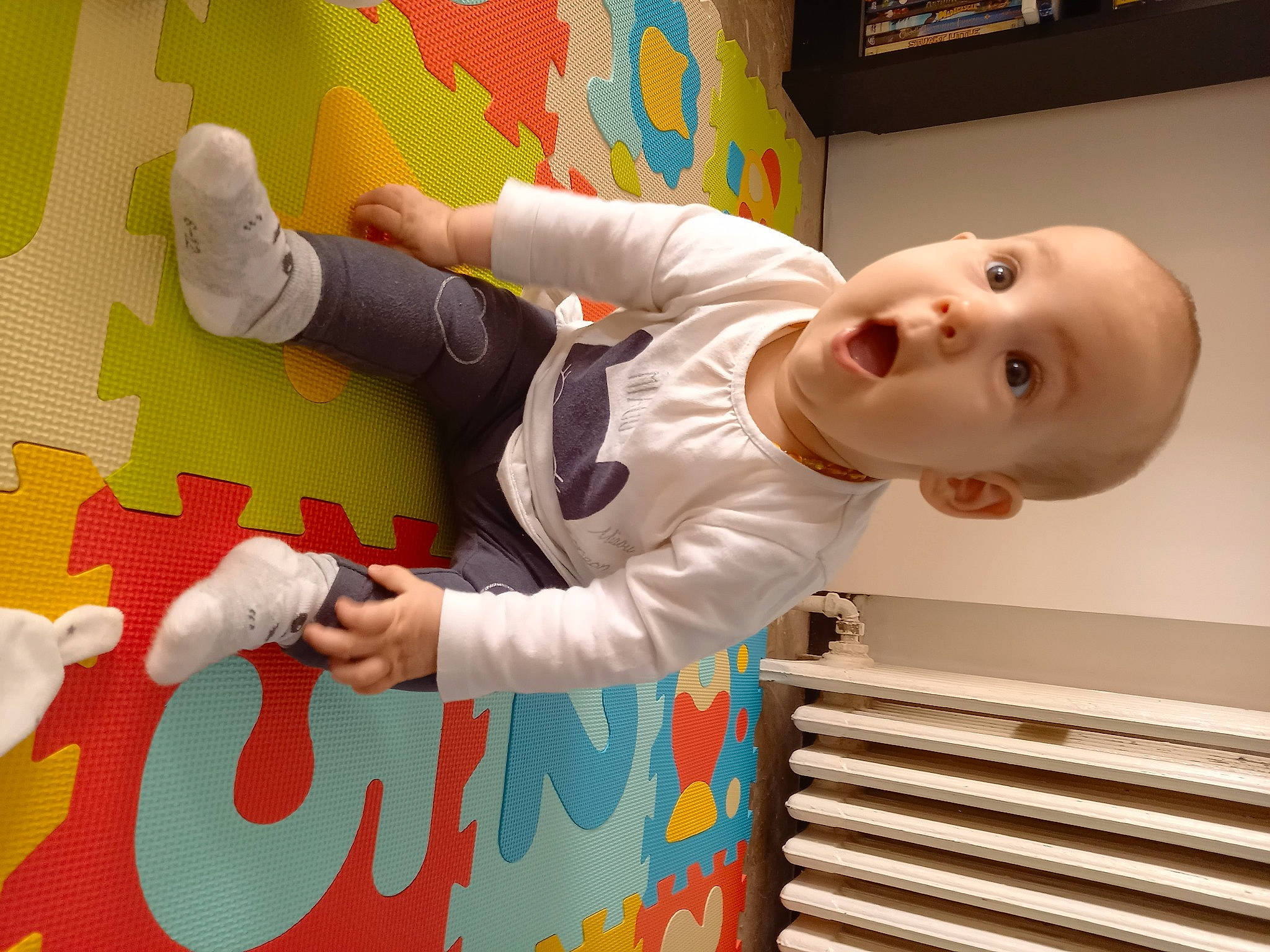 Ayna participe au concours pour gagner de l'argent avec cette photo : arm, baby, baby_toddler_clothing, child, comfort, facial_expression, finger, flooring, fun, gesture, hand, happy, pattern, person, play, room, sleeve, smile, surprise, t_shirt