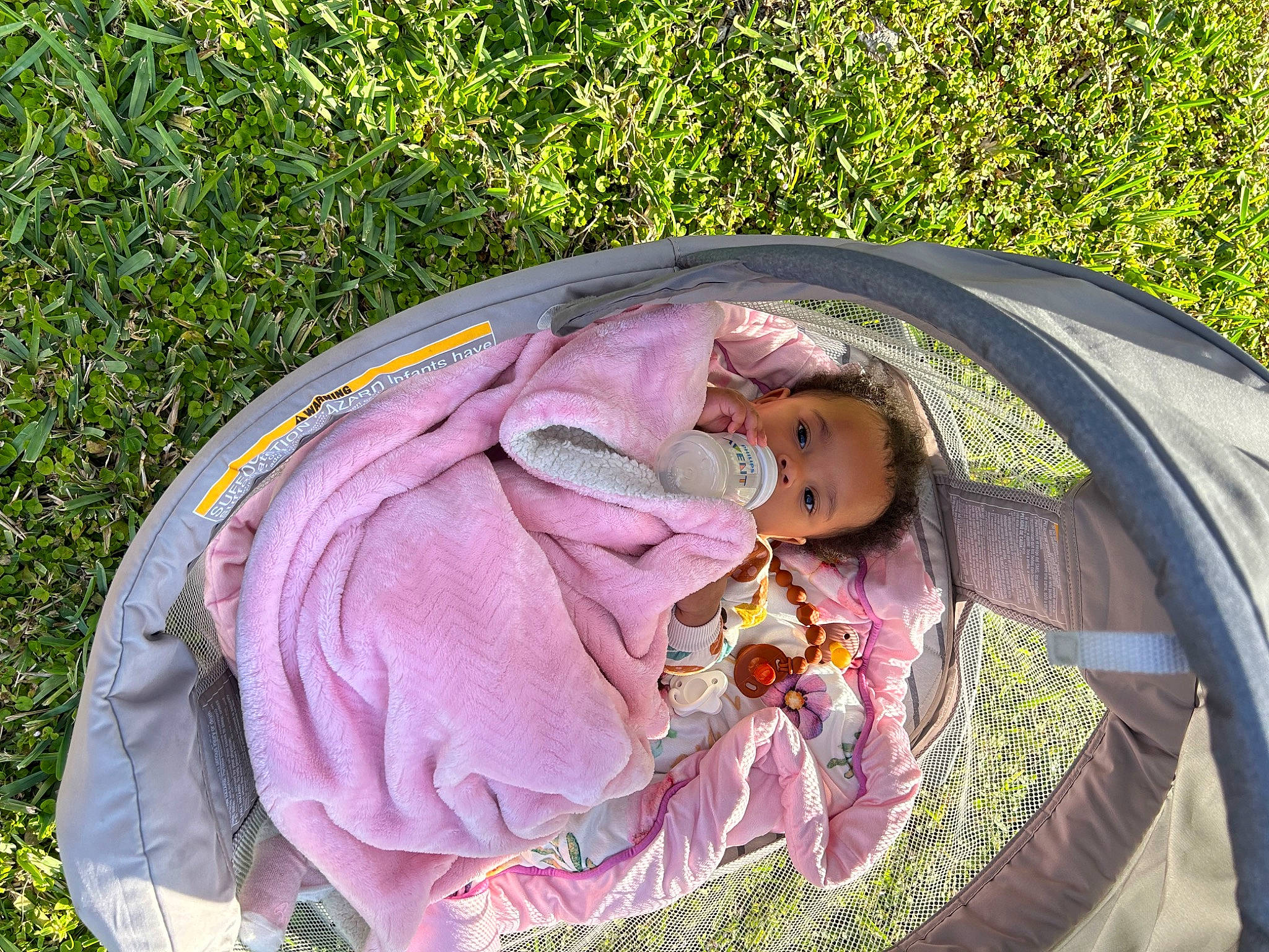 Valentina is registered to the contest to win money with this photo: baby, baby_carriage, baby_products, camping, child, fashion_accessory, fun, grass, happy, leisure, magenta, people_in_nature, person, personal_protective_equipment, pink, recreation, sitting, sun_hat, tent, toddler