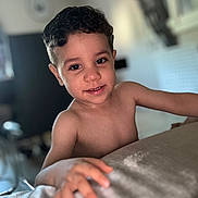 Naim a rejoint le concours — aidez-le/la à gagner de superbes lots ! child, boy, smile, curly_hair, indoor, portrait, skin, hand, face, young, cute, happy, person, childhood, closeup, expression, room, blurred_background, natural_light, casual
