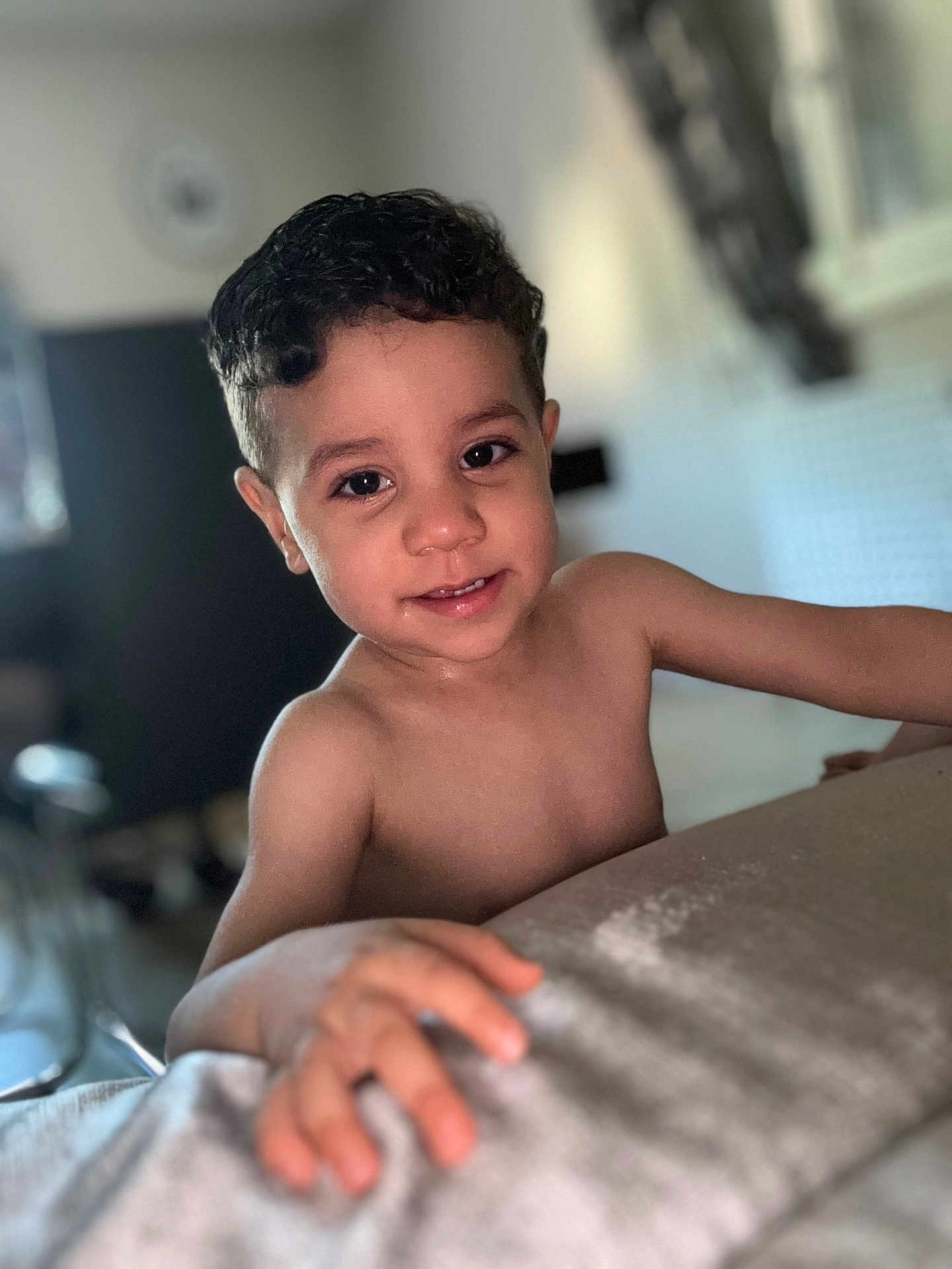Naim a rejoint le concours — aidez-le/la à gagner de superbes lots ! child, boy, smile, curly_hair, indoor, portrait, skin, hand, face, young, cute, happy, person, childhood, closeup, expression, room, blurred_background, natural_light, casual