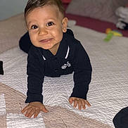 Chahine participe au concours pour gagner de l'argent avec cette photo : toddler, child, smiling, crawling, bed, quilt, indoors, face, hands, clothing, black_shirt, happy, cute, young_child, person, portrait, baby, skin, eyes, hair