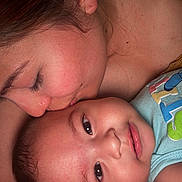 Santiago is registered to the contest to win money with this photo: affection, baby, child, close_up, clothing, cuddle, cute, expression, face, family, human, indoor, intimacy, kiss, love, mother, person, portrait, skin, tenderness